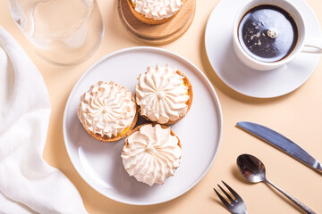 Sweet tart with cream and cup of coffee on beige table