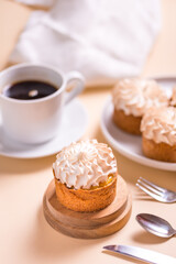 Sweet tart with cream and cup of coffee on beige table