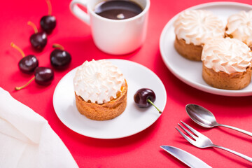 Sweet tart with cream and cherry on red table