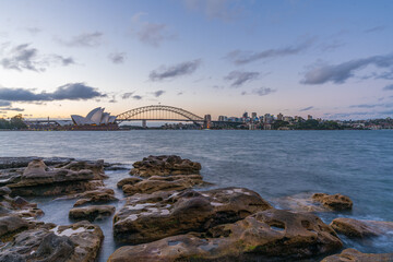 Naklejka premium Sydney harbor skyline at sunset with Sydney harbor bridge, NSW, Australia
