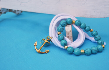 summer jewelry - turquoise gemstone bracelet and gold anchor charm © photo_stella