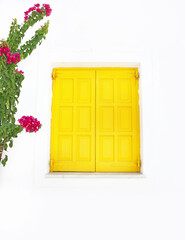 traditional yellow window and bougainvillea flower at Ano Koufonisi island Greece
