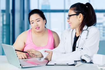 Obraz premium Doctor discussing with her fat patient in hospital