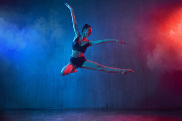 Slim ballerina jumping under rain.