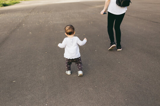 First Steps Of Little Girl. Mother And Her Toddler On Playground. Baby Girl Running Away Trying To Catch Her Mom.