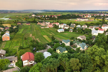 Aerial landscape of small town or village with rows of residential homes and green trees. - obrazy, fototapety, plakaty