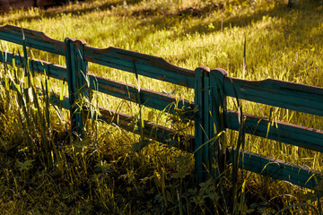 Shabby wooden fence in provence style during golden hour with contrast light