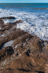 rocky beach with foamy sea water