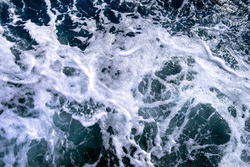 Top down aerial view of sea water surface. White foam waves texture as natural background.