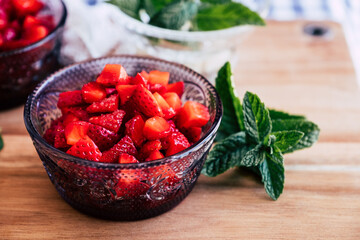 Salade de fruits frais - Fraises au sucre et menthe fraiche dans un bol