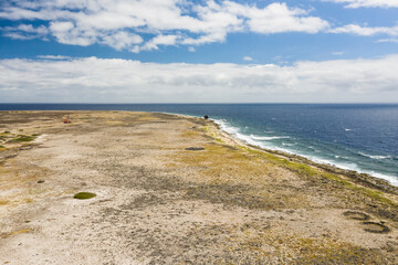 Aerial view of coast of Klein Curacao in the Caribbean Sea with turquoise water, cliff, beach and beautiful coral reef