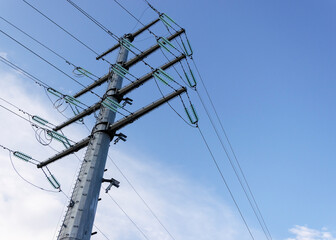 Pillar and power lines against a cloudy sky