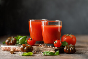 Tomato juice and fresh tomato with basil on rustic background