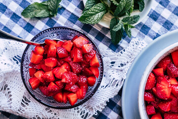 Salade de fruits frais - Fraises au sucre et menthe fraiche dans un bol © PicsArt