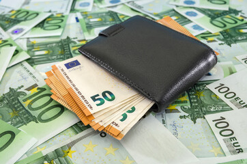 black men's wallet with 50 euro banknotes. A lot of euro banknotes. Financial concept. Money background.Thick wallet with money