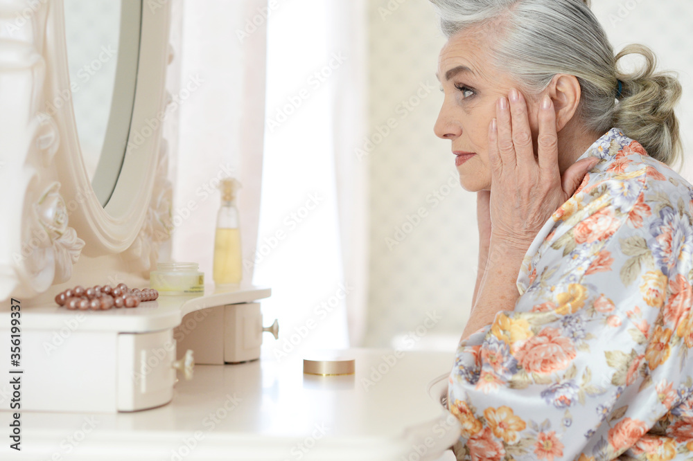 Sticker Happy senior woman sitting near dressing table