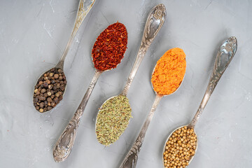 Variety of herbs and spices on slate background.