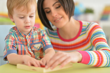 Close up portrait of young mother playing with son