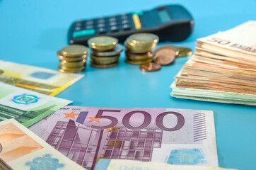 500 euro banknote, calculator and coins on a blue background. Business concept. Savings concept.