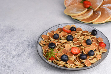 Fototapeta na wymiar Tiny pancake cereal With Strawberries And Blueberries for breakfast. Food Background.