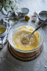 Step by step process of making yeast bread. Mixing butter in batter with a whisk.