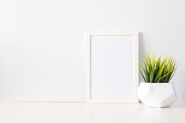 White mockup frame with green grass in a geometric pot.