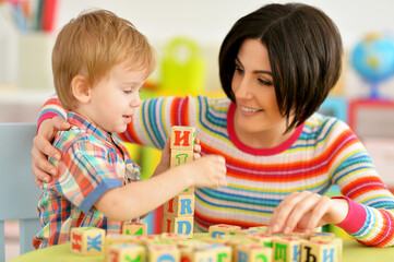 Woman and little boy playing with cubes