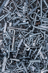 pile of metal screws, nuts and bolts. Blue filter photo. Metal fasteners assortment. Fasteners fittings