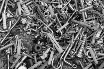 pile of screws and bolts. Monochrome photo. Metal fastening manufacture. Hardware for repair or fixing
