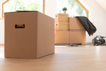 Move. Cardboard boxes for moving into a new, clean home. In a sunny day by a window in attic.