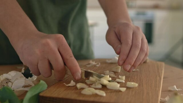 CU Boy (10-11) cutting garlic on cutting board / Lyngby,Denmark