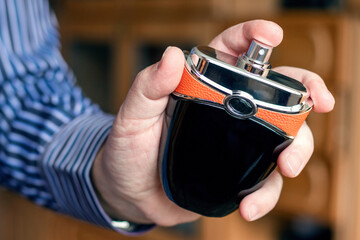 Bottle of perfume in a man's hand