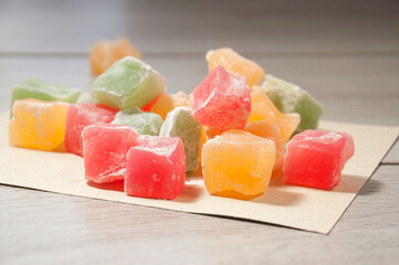 Colorful turkish delight cubes scattered on a wooden table. Traditional turkish sweets.