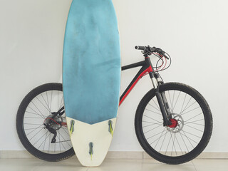 Mountain bike and surfboard at home. Lifestyles.