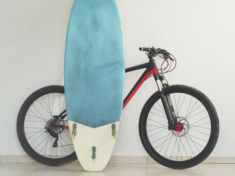 Mountain bike and surfboard at home. Lifestyles.