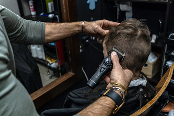 Hairdresser cuts the hair of a boy in a barbershop