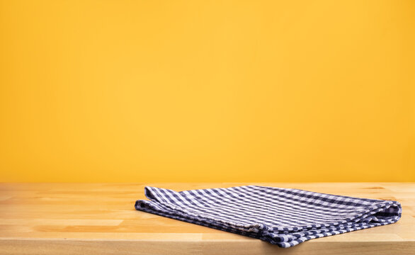 Blue Fabric,cloth On Wood Table Top On Yellow Wall Background.