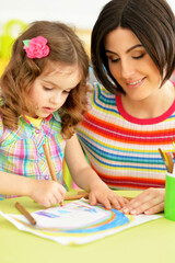 Close up portrait of little cute girl with mother drawing
