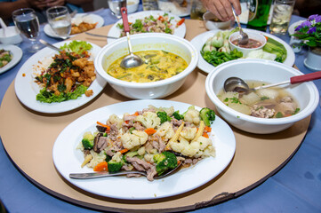 having dinner with Thai food on Chinese dishes in Thailand