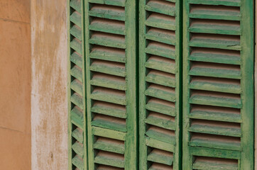 Close up photo of a Green wooden window shutters.