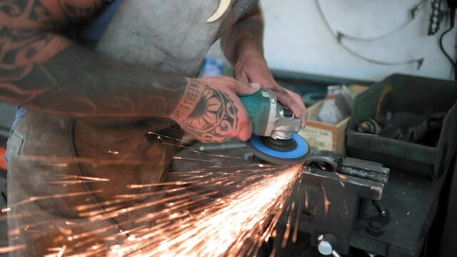 MS Man working with grinder in workshop / Mariano Comense, Como, Italy
