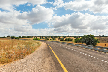 Fototapeta na wymiar Road in the Golan Heights against the backdrop of beautiful clouds