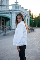 Portrait of a fashionable brunette. Long dark hair and bright red lipstick. The girl looks at the camera