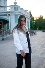 Portrait of a fashionable brunette. Long dark hair and bright red lipstick. The girl looks at the camera