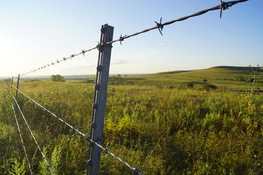 A barbed wire fence separates ranch properties in the Flint Hills of rural Kansas.