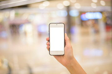 woman hand is holding cell phone mockup on shopping center background