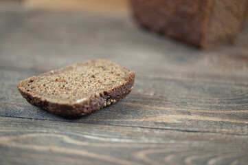 a loaf of black bread on a wooden background, the concept of rising bread prices