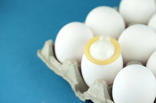 eggs and a top-clad condom, a concept of protection against pregnancy and disease - Powered by Adobe