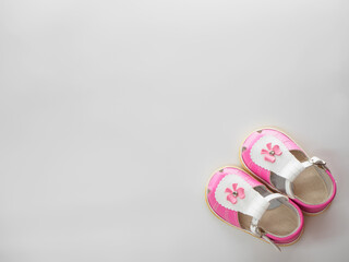 Top view of pair of white pink sandals with clasps fasteners at white background with place for text