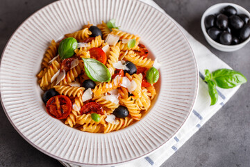 Pasta fusilli with cherry tomatoes, basil and olives. Homemade pasta 